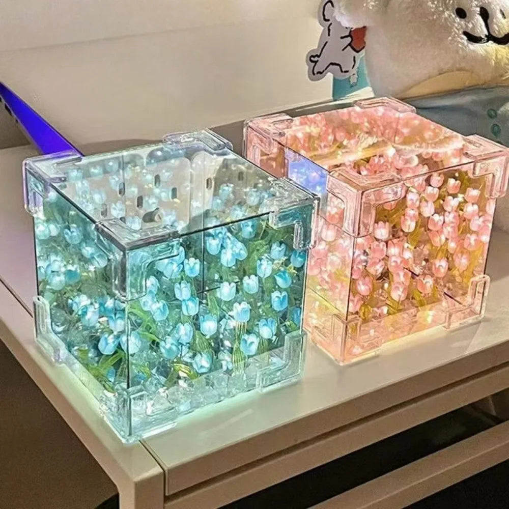 Creative Tulip Flower Sea Cube night light featuring transparent cube-shaped lamps with illuminated artificial tulips in blue and pink variations, creating an ethereal underwater effect on a white surface. Each cube contains multiple glowing flowers with LED lighting for ambient decoration.