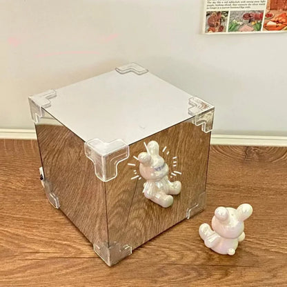 Creative Tulip Flower Sea Cube - Transparent acrylic cube display case with decorative corner joints, positioned on wooden surface. Iridescent ceramic figurines resembling small creatures visible near the cube, creating an elegant minimalist presentation.