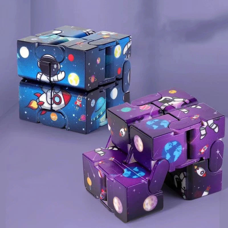 Infinity Magic Cube displayed in blue and purple variants with space-themed designs featuring astronauts, rockets, and planets. The cubes show segmented blocks that can be manipulated and folded in various patterns against a purple background.