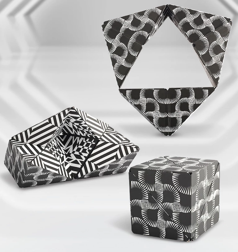 Magnetic Magic Cube Puzzle Cube shown in three different configurations displaying black and white geometric patterns on its surfaces. The transformable cube features optical illusion-like designs with radiating lines and checkered effects against a light background.