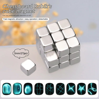 A sleek silver magnetic cube composed of 27 detachable metallic blocks is displayed on a reflective surface with a blurred background of yellow flowers. One cube piece is shown separately with a label indicating "5mm/27pcs." The text overlay describes the product as a "Chess board Rubik's cube magnet" with features such as "Fast magnetic attraction, easy operation, detachable." Below the cube, a row of glossy black nail designs with glowing blue patterns is featured, adding a futuristic aesthetic.